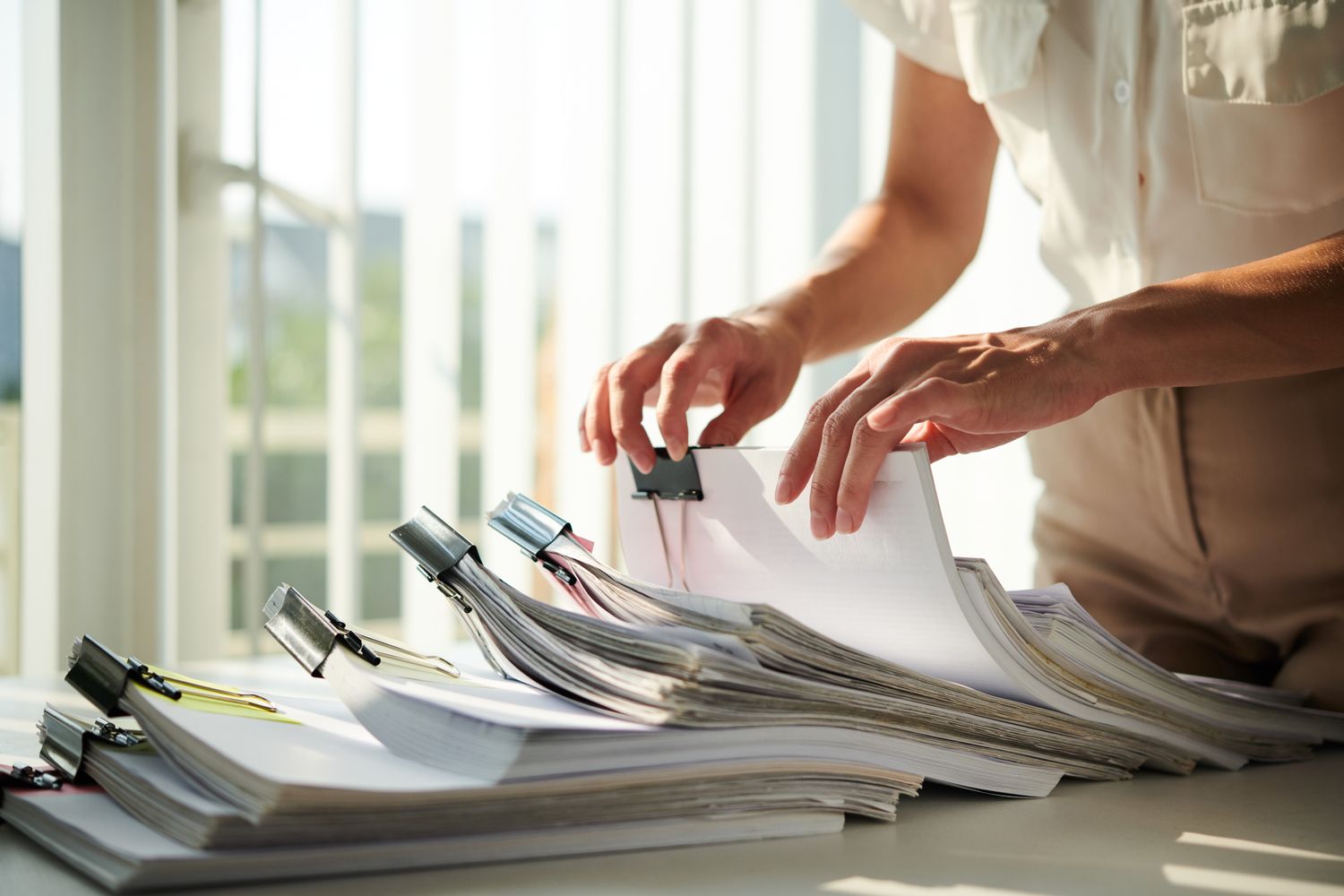Hands of businesswoman searching for report in archive