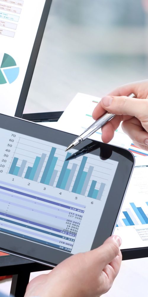 Business colleagues working and analyzing financial figures on a digital tablet