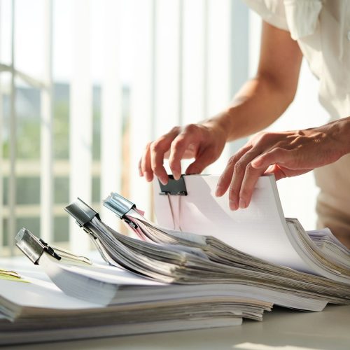 Hands of businesswoman searching for report in archive